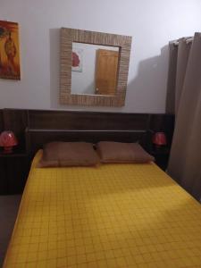 a bedroom with a yellow bed with a mirror at Charmant bungalow du Moule in Le Moule
