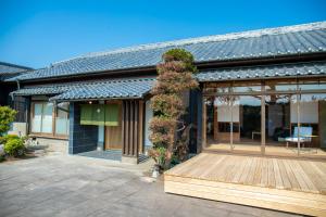 a house with a wooden deck with a plant on it at 貸切宿 茶心 in Shintomi
