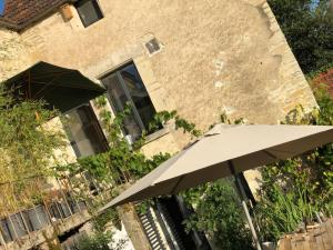 an umbrella sitting in front of a building at Maison rivière très calme près de Chablis et Noyers sur serein chez un céramiste designer in Annay-sur-Serein