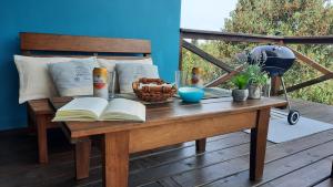 a wooden table with an open book on a deck at Marasaias in La Pedrera