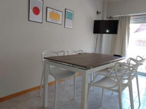 stół jadalny z krzesłami i telewizor w obiekcie La Perla w mieście Mar del Plata