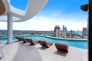 a pool on the roof of a building with chairs at The Gallery Broadbeach - GCLR in Gold Coast