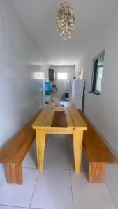 a wooden table in the middle of a room at Casinha de Sapê in Santo Amaro
