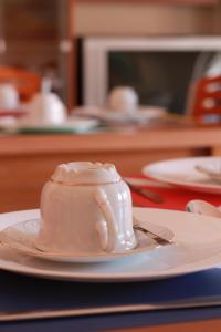 a white coffee cup on a plate on a table at Altea in Pescara