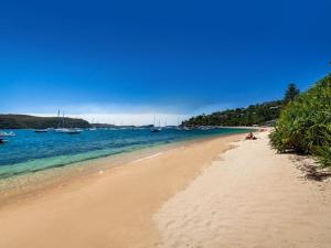einen Sandstrand mit Booten im Wasser in der Unterkunft The Lighthouse at Iluka Resort Apatments in Palm Beach