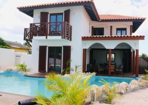 a house with a swimming pool in front of it at Neue Villa TROPIC PARADISE in Willemstad