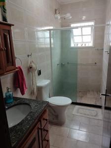 a bathroom with a shower and a toilet and a sink at Casa Area Gourmet in Araruama