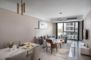 a dining room and living room with a table and chairs at Citadines New District Wuxi in Wuxi