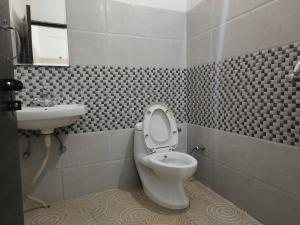 a bathroom with a toilet and a sink at Vidya Guest House in Katra