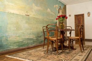 Un comedor con una mesa y sillas y un cuadro. en Hotel Boutique Inca Real, en Cuenca