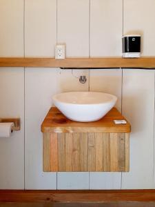a bathroom with a bowl sink on a wooden shelf at Bugambilias Alojamiento in Brisas de Zicatela