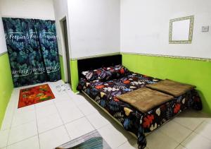 a bedroom with a bed in a green room at Homestay Cameron Highlands Mikayla in Cameron Highlands