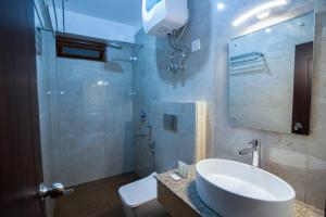 a bathroom with a sink and a toilet and a mirror at Hotel Shambhala in Gangtok +26 photos