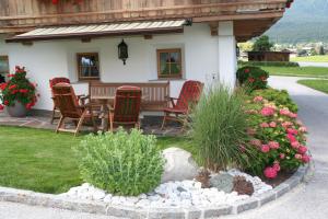 eine Veranda eines Hauses mit Stühlen und Blumen in der Unterkunft Appartement Kichelerhof in Strass im Zillertal