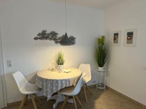 ein Esszimmer mit einem Tisch und weißen Stühlen in der Unterkunft Margaritenhaus Heinze in Westerland