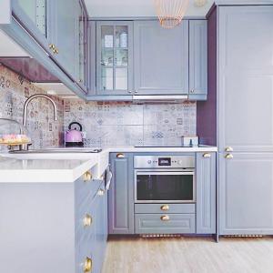 una cucina con armadi blu e forno in acciaio inossidabile di The Little White House, Suite Flower Beach 9 a Playa Honda