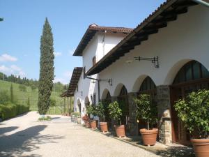 a building with a row of potted plants on a sidewalk at Agriturismo Giorgio Colutta in Manzano