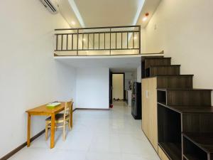 ein Wohnzimmer mit einem Tisch und einer Treppe in der Unterkunft Smiley Apartment Quận 2 in Ho-Chi-Minh-Stadt