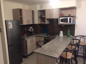 Departamento de descanso frente al mar في لا سيرينا: مطبخ مع ثلاجة سوداء وقمة كونتر