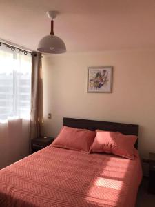 Departamento de descanso frente al mar في لا سيرينا: غرفة نوم مع سرير مع لحاف احمر