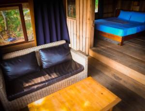 a couch and a bed in a room at Lazy Beach in Koh Rong Sanloem