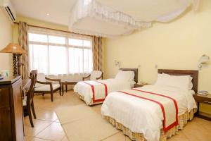 Een bed of bedden in een kamer bij New Safari Hotel