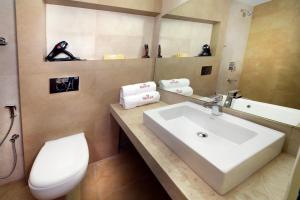 a bathroom with a sink and a toilet and a mirror at HOTEL THE FORTUNE in Coimbatore