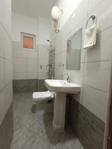 a white bathroom with a sink and a toilet at City Centre in Mombasa