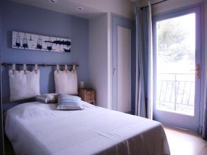 um quarto com uma grande cama branca e uma janela em Farniente em Le Lavandou