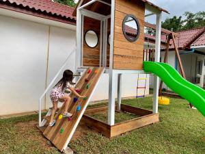 a little girl playing on a slide on a playground at River View Villas in Vang Vieng