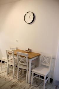 a dining room table and chairs with a clock on the wall at P&K Motlawa Apartment in Gdańsk