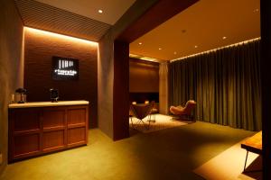 a hotel room with a reception desk and a chair at Riverside Hotel Sapporo in Sapporo