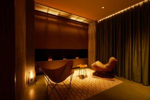 a living room with two chairs and a fireplace at Riverside Hotel Sapporo in Sapporo