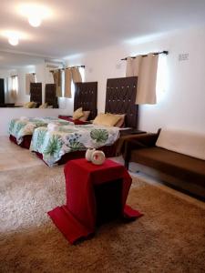 um quarto com 2 camas e uma mesa vermelha em Friends Place em Joanesburgo