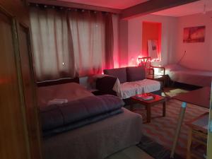a living room with pink lighting and a couch at Terrace Roof Room @ Koridallos Metro St. & Piraeus Port in Piraeus