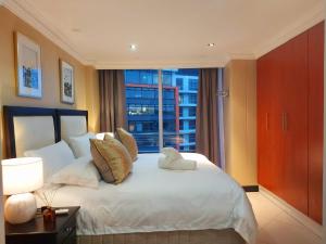 a bedroom with a large white bed with a window at Ocean Sunrise at the Sails - Durban point waterfront in Durban