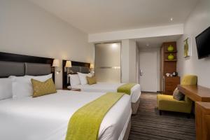 a hotel room with two beds and a desk at Premier Hotel Midrand in Midrand