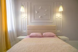 a bedroom with a bed with two pink pillows at Family Apart-Hotel Les Amis in Adler