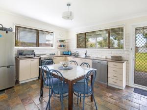 a kitchen with a table and chairs in it at Roskell Retreat Pet Friendly 5 Mins Walk to Beach in Callala Beach