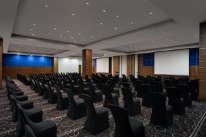 una sala de conferencias vacía con sillas y una pantalla en Premier Hotel Midrand, en Midrand