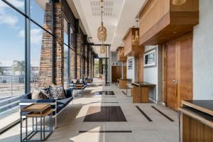 an office lobby with couches and tables and windows at Premier Hotel Midrand in Midrand