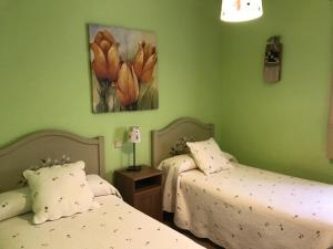 2 camas en una habitación con paredes verdes en La Senda Del Duratón en Sebúlcor