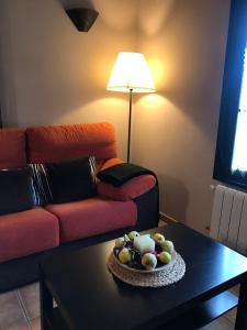 sala de estar con sofá y mesa con un bol de fruta en La Senda Del Duratón, en Sebúlcor