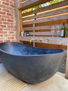 a large bath tub sitting on a table with wine glasses at The Little House in Inverloch