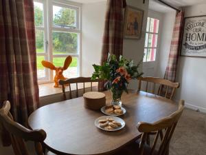 a dining room table with a plate of food on it at Honeysuckle Cottage in Dorchester +27 photos