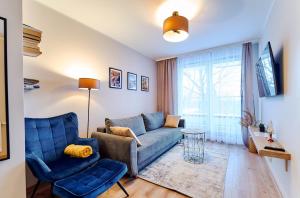 sala de estar con sofá azul y silla azul en LAGUNA Apartament Polanica Residence 12, en Polanica-Zdrój