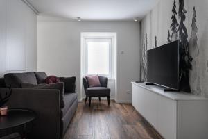 a living room with a couch and a flat screen tv at Casa D‘Antino in Titisee-Neustadt