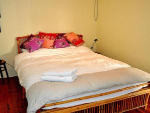 a bed with colorful pillows on it in a room at Minnamurra Villa on the River in Minnamurra