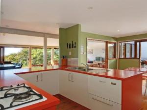 a kitchen with green and white cabinets and a stove at Minnamurra Villa on the River in Minnamurra