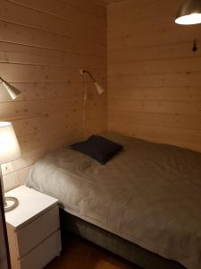 ein Schlafzimmer mit einem Bett mit einer Lampe und einem Nachttisch in der Unterkunft Air-conditioned holiday home Vutnusmaja at Iso-Syöte in Syöte